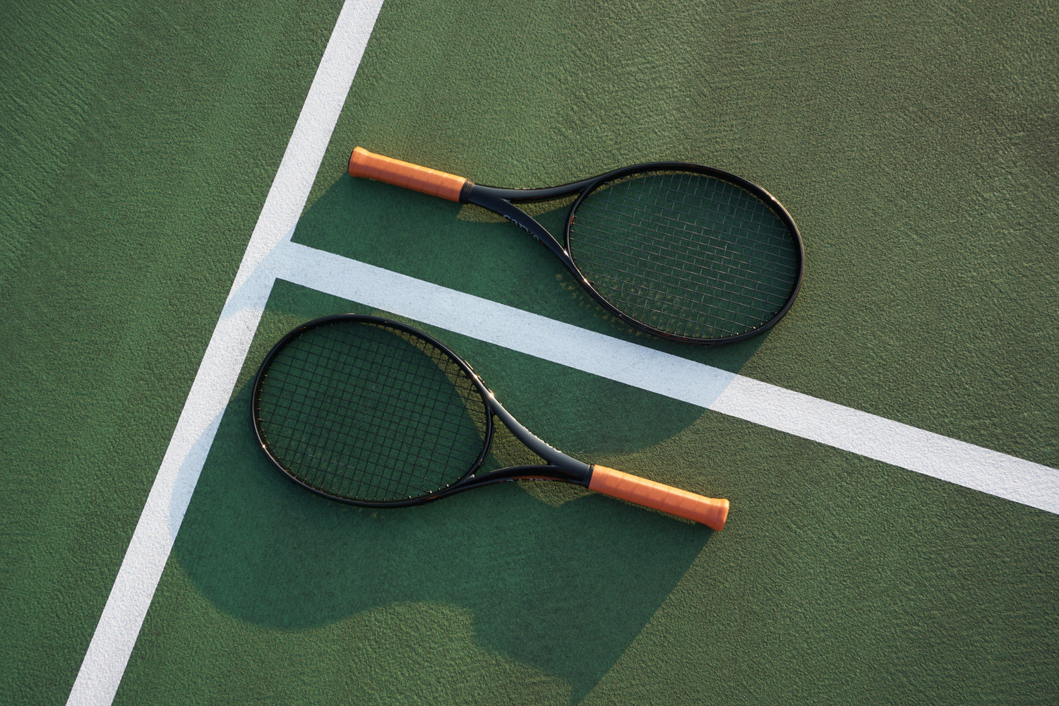 Black tennis racket on green court
