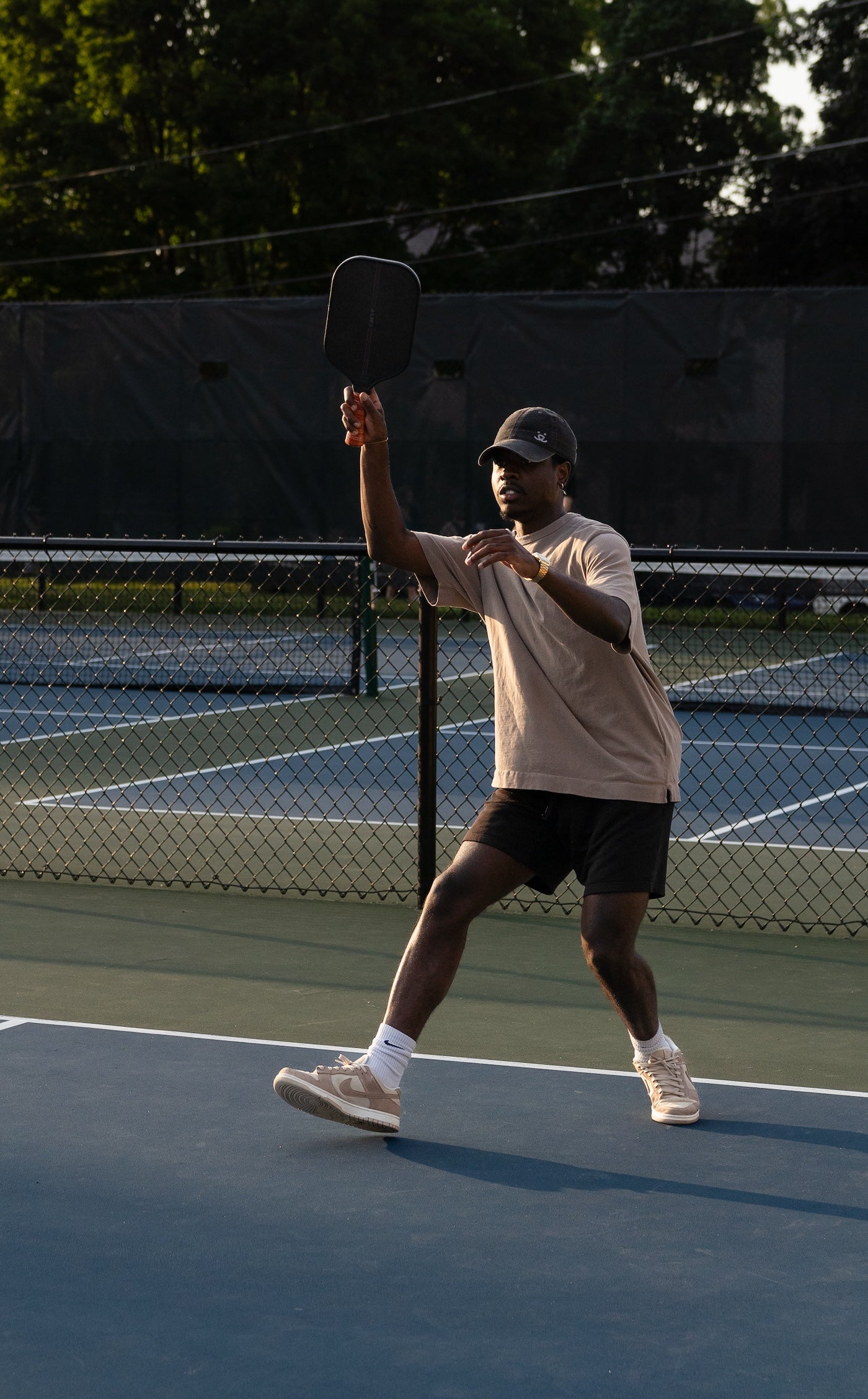 Black male on a pickleball court with a Carve AllCourt 14mm Paddle