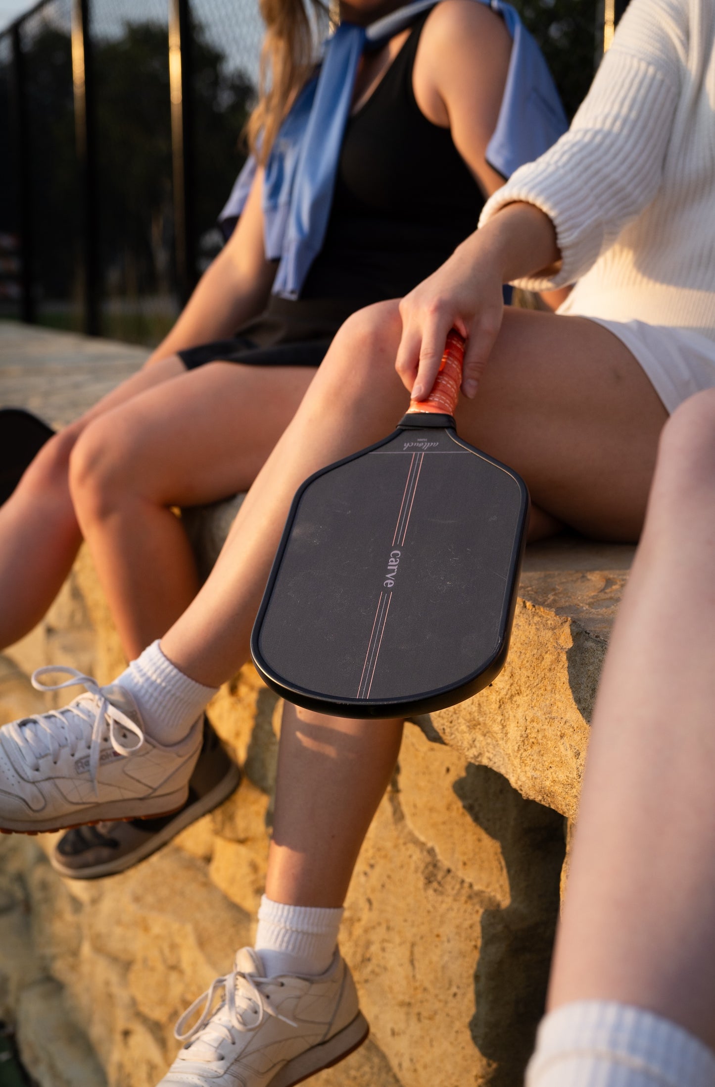 Image of females on a stone ledge with a Carve AdTouch Paddle